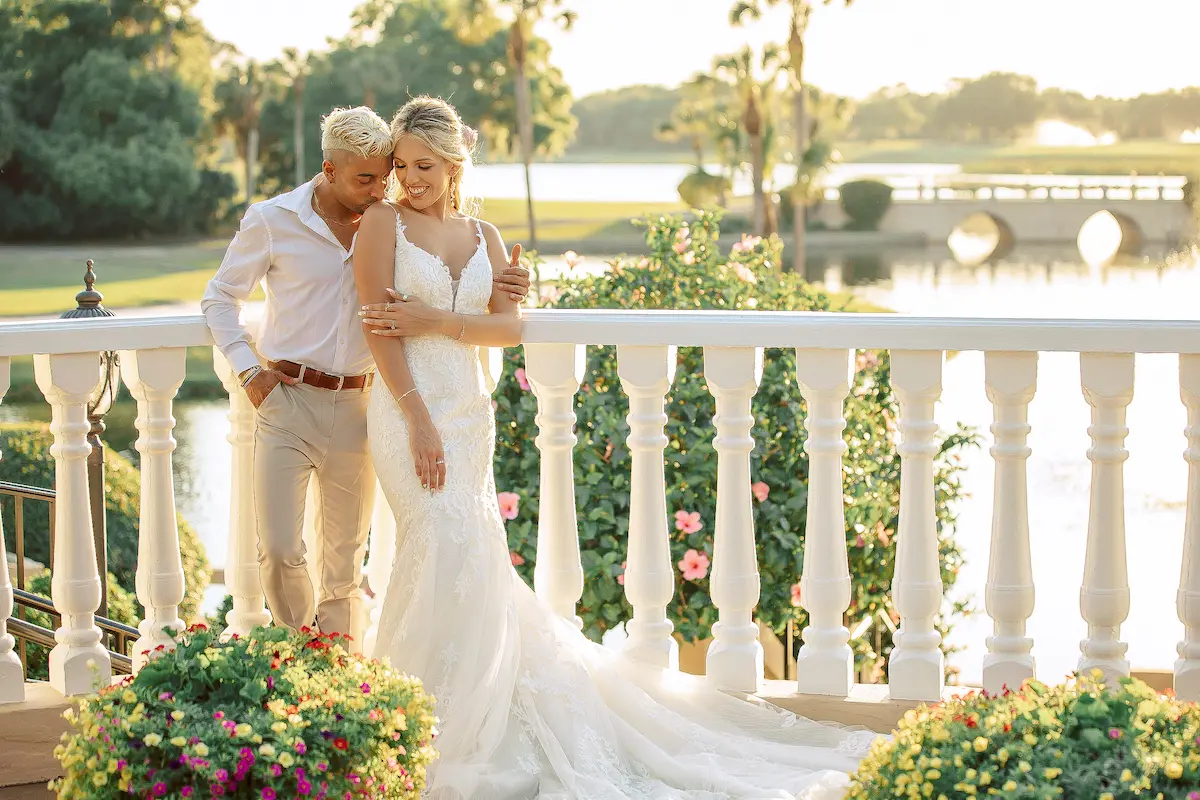 Romantic wedding couple embracing on a sunny garden balcony