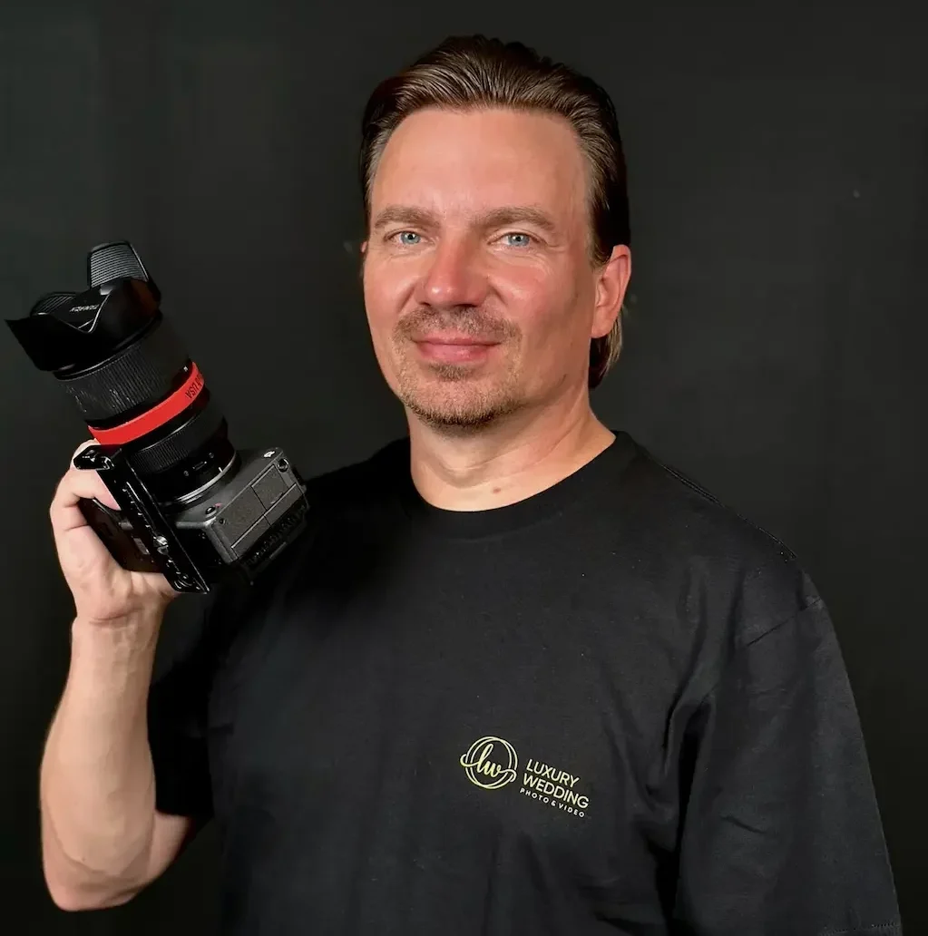 Experienced wedding videographer holding a professional camera.